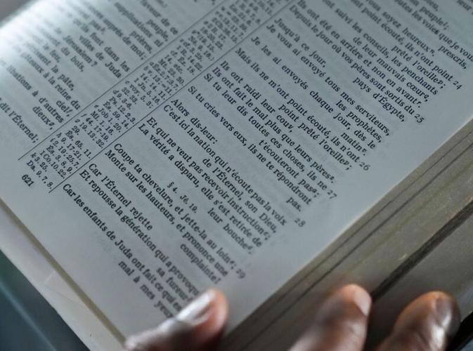 Seventh Day Adventist pastor Michelet William stands at a pulpit as he reads out Jeremiah 7:1-7 in French for a photo Monday, July 13, 2026, at the church he leads on the west side of Indianapolis. William’s congregation includes Haitian worshippers, ma...