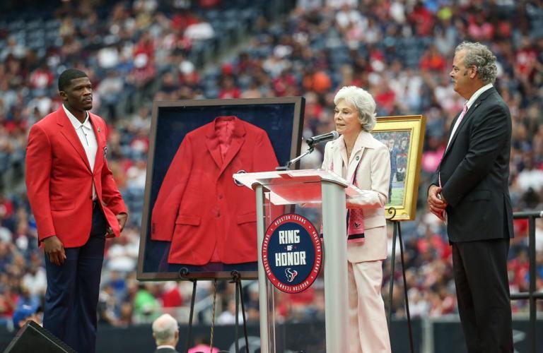 Oct 6, 2019; Houston, TX, USA; Houston Texans former player Andre Johnson (left) and chairman and chief operating officer D. Cal McNair (right) look on as senior chair Janice McNair (middle) addresses the crowd as late owner Bob McNair is inducted into the