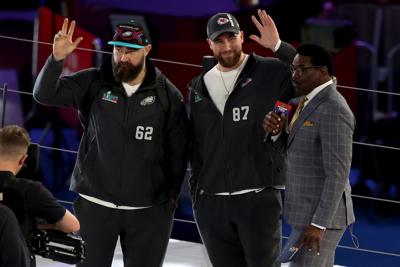 Brothers Jason Kelce of the Philadelphia Eagles and Travis Kelce of the Kansas City Chiefs wave onstage during Super Bowl LVII opening night festivities at Footprint Center on Feb. 6, 2023, in Phoenix.