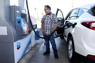 Juan Galaiviz pumps gas into his automobile at a Chevron gas station on March 8, 2022, in Orange, California.