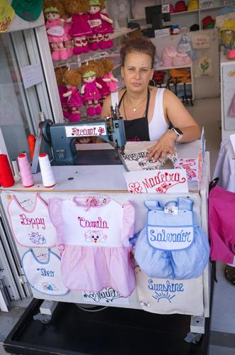 A woman embroidering children's clothes, Funchal, Madeira.