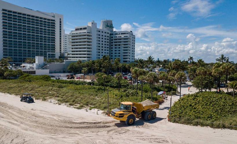 A truck loaded with sand turns off of Collins Avenue to restore a stretch of beach near Indian Beach Park on Wednesday, Oct. 12, 2022, in Miami Beach, Florida.