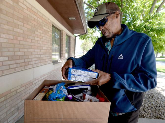 Davine Oliver looks over some of the groceries he received at the Holy Family Food Pantry on May 13, 2026, in Springfield, Illinois.