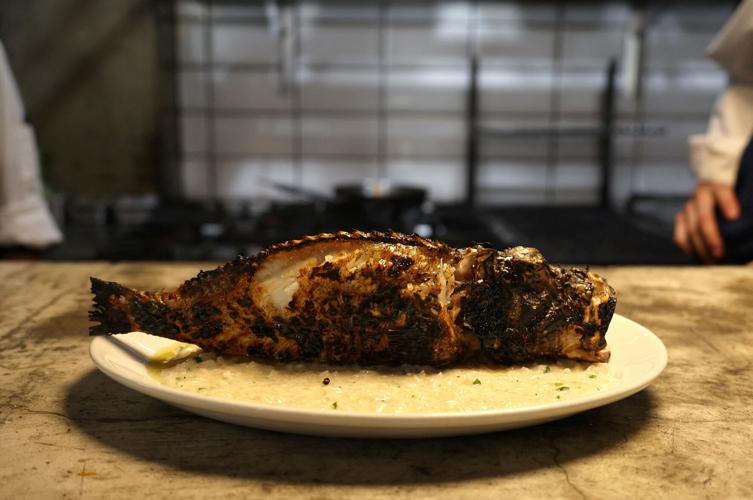 A lionfish with risotto is served on a plate in a restaurant in the coastal city of Limassol