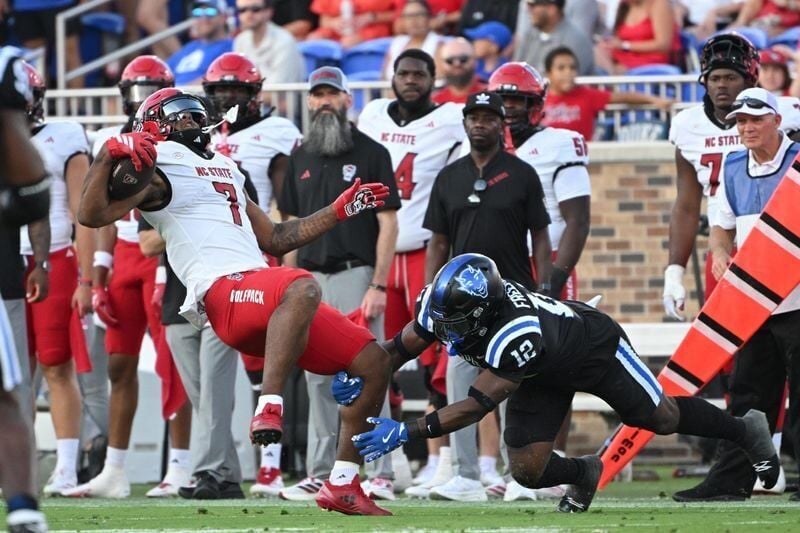 Sep 20, 2025; Durham, North Carolina, USA;  Duke Blue Devils linebacker Tre Freeman (12) tackles North Carolina State Wolfpack cornerback Brian Nelson II (7) during the third quarter at Wallace Wade Stadium. Mandatory Credit: Zachary Taft-Imagn Images