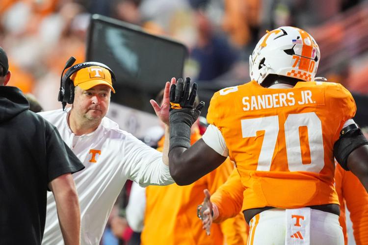 Tennessee coach Josh Heupel high-fives Tennessee offensive lineman David Sanders Jr. (70) during a football game between