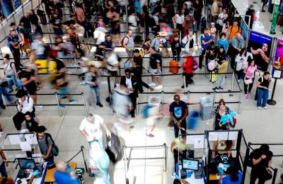 People wait in a security line at John F. Kennedy International Airport on Aug. 12, 2026, in the Queens borough of New York City. A union representing 47,000 Transportation Security Administration workers is suing the TSA over a new program introduced b...