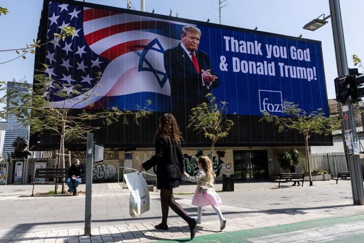 People walk by a billboard commissioned by an evangelical group, amid the U.S.-Israel conflict with Iran, in Tel Aviv