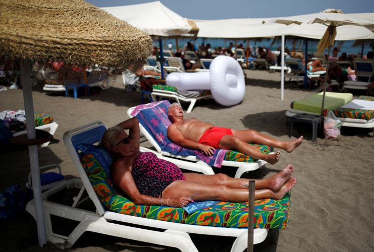 FILE PHOTO: Tourists sunbathe on La Carihuela beach on a hot summer day during the first weekend of the summer in Torremolinos