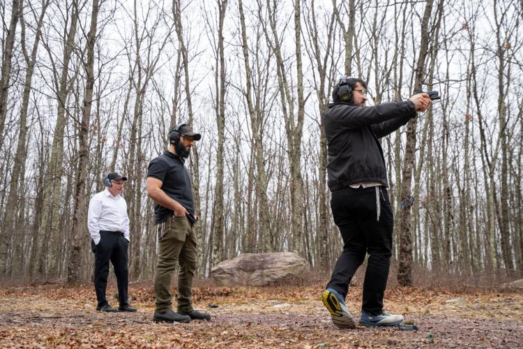 Zalmy Cohen practices his footwork while shooting with instruction from Raziel Cohen, middle, at a private gun range on Sunday, March 22, 2026, in Pennsylvania.