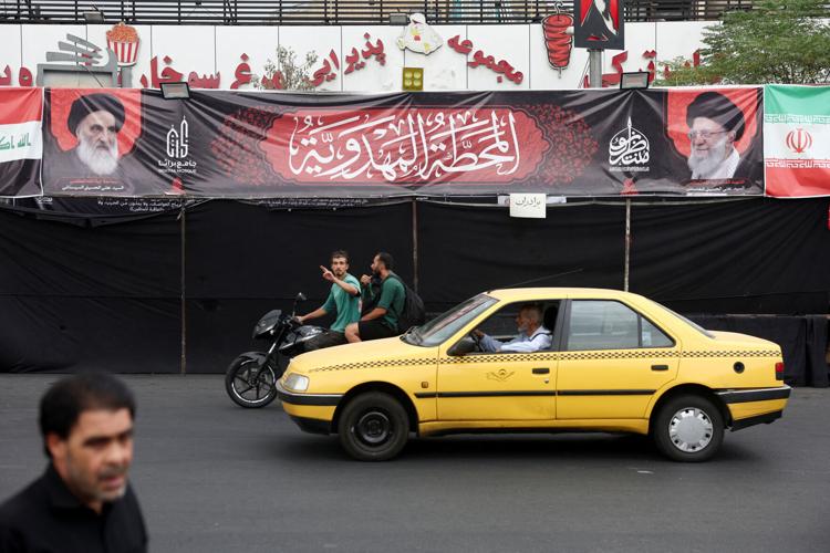 A banner shows pictures of Iraq's top Shi'ite cleric, Grand Ayatollah Ali al-Sistani and Iran's late Supreme Leader Ayatollah Ali Khamenei, in Tehran
