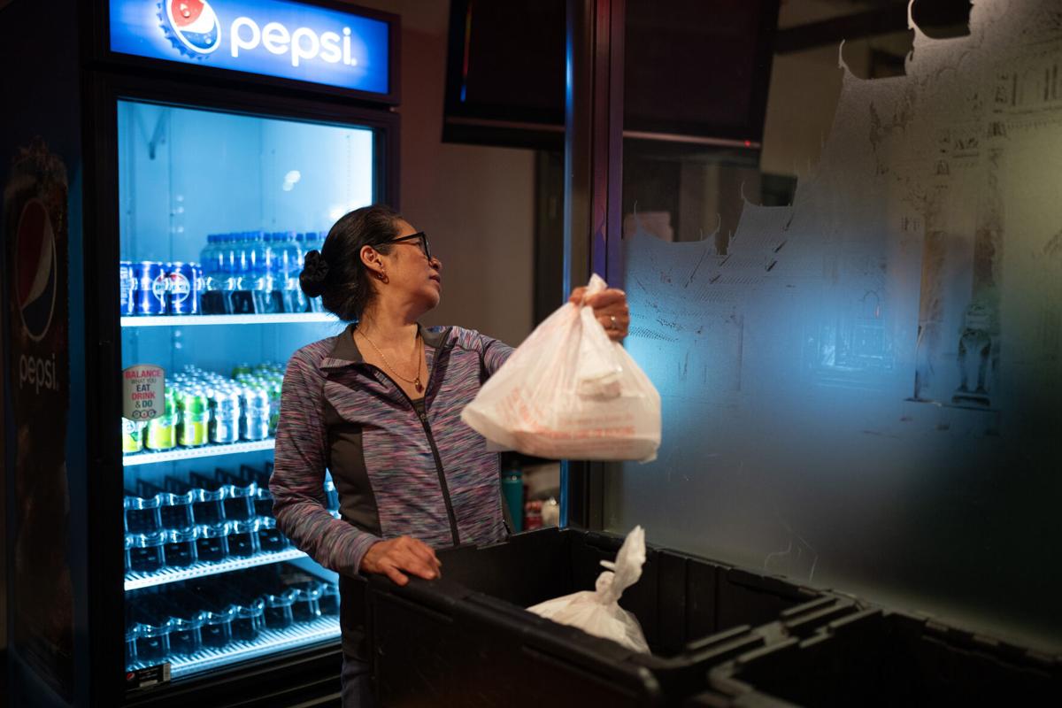 Sam Simonson looks for the correct takeout order for a waiting DoorDash delivery person at Sawatdee in Minneapolis on Thursday night, Dec. 14, 2023.