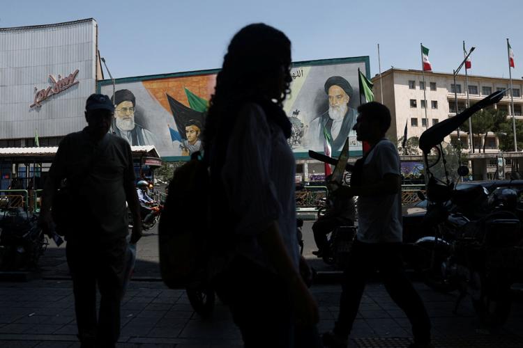 People walk past a mural depicting the late leader of the Islamic Revolution, Ayatollah Ruhollah Khomeini, and the late Iran's Supreme Leader Ayatollah Ali Khamenei, on a street in Tehran