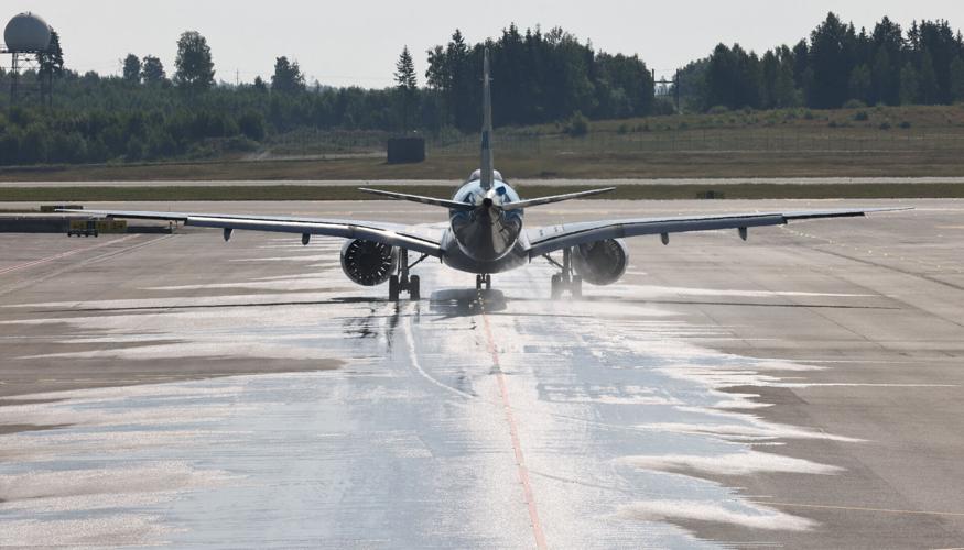 A plane drives on the wet runway at the airport in Oslo