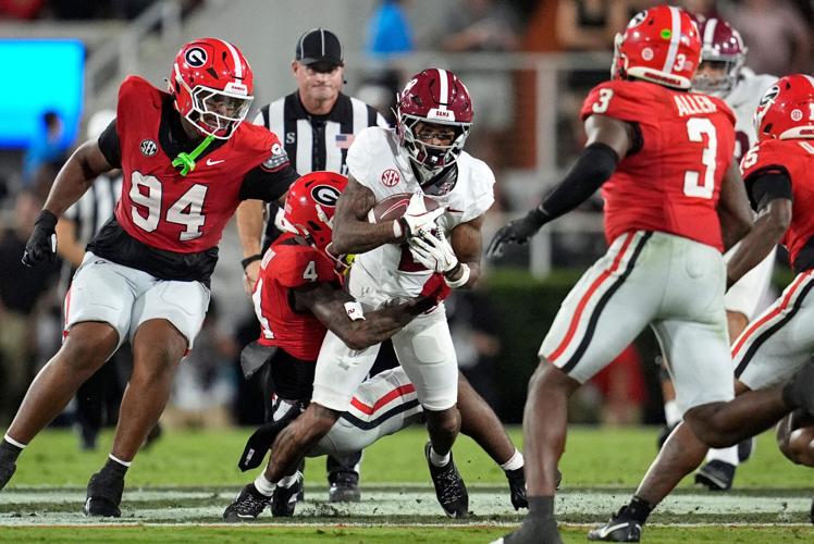 Georgia defensive back KJ Bolden (4) tackles Alabama wide receiver Ryan Williams (2) during their game at Sanford Stadium.