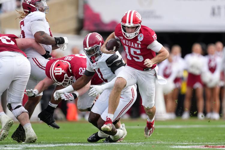 Indiana quarterback Fernando Mendoza (15) runs the ball while being pursued by Alabama defensive lineman Jordan Renaud (11) during the 2026 Rose Bowl at Rose Bowl Stadium.
