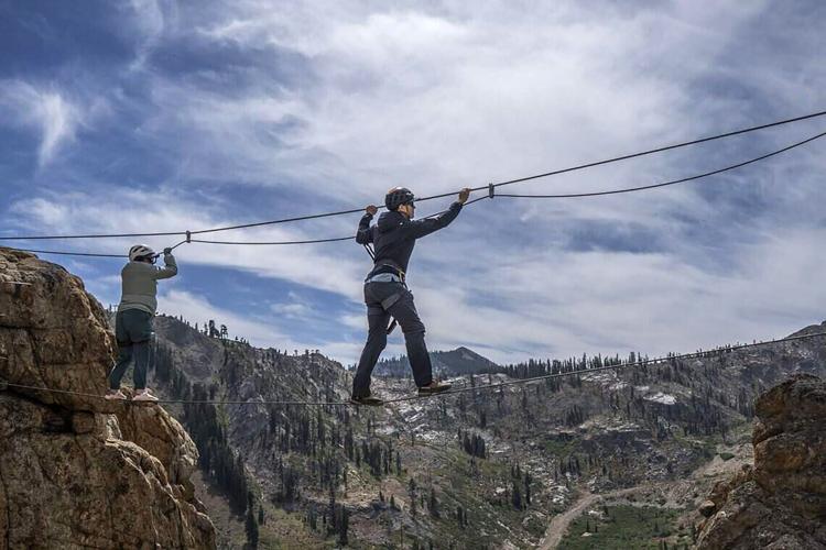 Tim Mincey, a mountain guide at Alpenglow Expeditions, leads Sacramento Bee writer Camila Pedrosa on the Super Monkey Bridge during a tour of the Tahoe Via Ferrata at Palisades on Tuesday, Sept. 1, 2026.