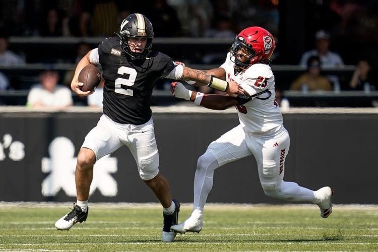 Vanderbilt quarterback Jared Curtis (2) evades NC State linebacker Sterling Dixon (25) during the fourth quarter at FirstBank Stadium in Nashville, Tenn., Saturday, Sept. 19, 2026.