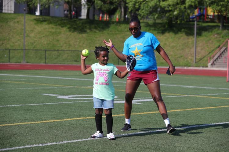 Yanava "Navi" Hawkins is leading the girls softball camp as part of new MLB-RBI commitment in city. she's working with a girl named Monroe McDonald