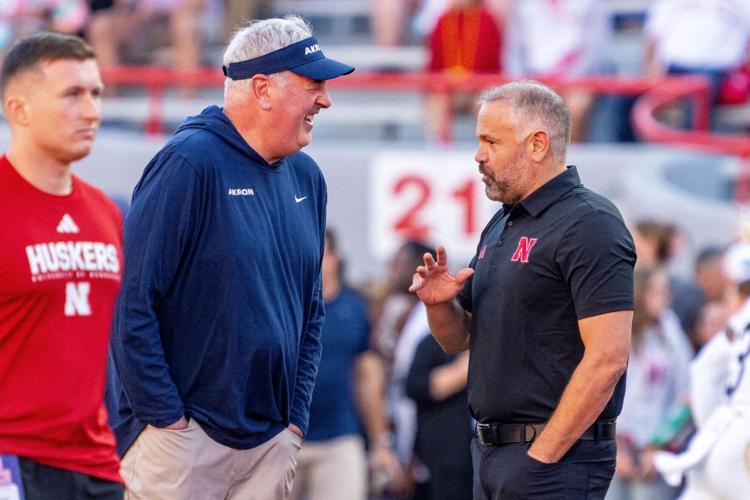 Sep 6, 2025; Lincoln, Nebraska, USA; Akron Zips head coach Joe Moorhead and Nebraska Cornhuskers head coach Matt Rhule talk before the game at Memorial Stadium. Mandatory Credit: Dylan Widger-Imagn Images