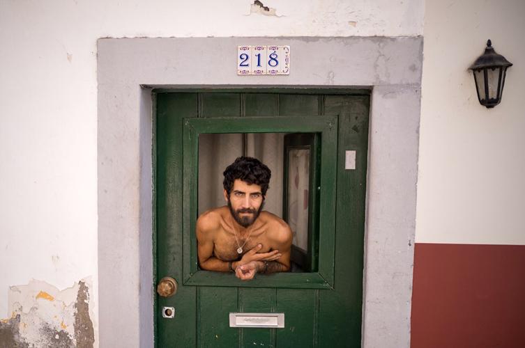 Man in a window, back street in Funchal, Madeira.