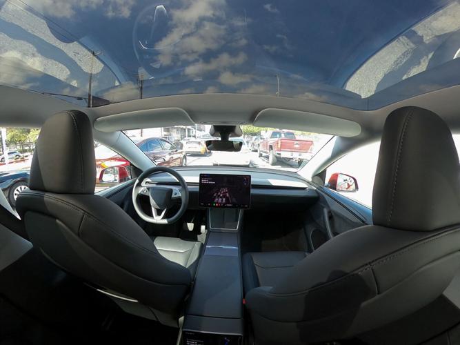 A Tesla Robotaxi vehicle drives through traffic in Austin