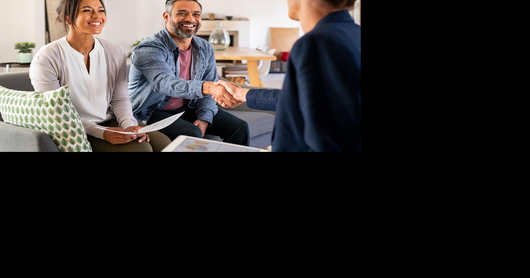 Mature indian man shaking hands with financial advisor at home. Happy smiling couple greeting broker with handshake at home. Multiethnic mid adult man and hispanic woman sealing a contract.
