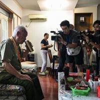 Wen Yunfu (L), 96, veteran of the Second Sino-Japanese War, sips a beverage after being interviewed in Yangquan, in China's northern Shanxi province