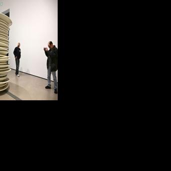 Visitors look at "No title (stacked plates, white)," a 1993 large-scale art work by Robert Therrien, during the exhibition "Robert Therrien: This is a Story" at The Broad in Los Angeles, California