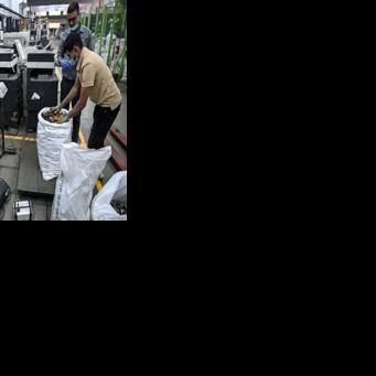 Workers weigh dismantled electronic parts at 'Ecowork', an e-waste recycling facility in Ghaziabad, India