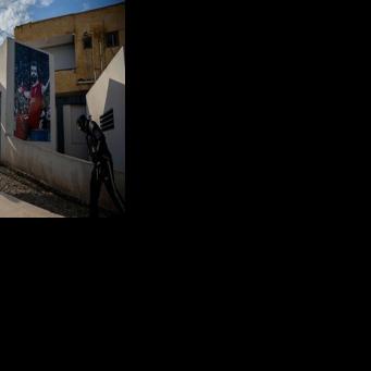 Locals pass a mural of Mohamed Salah at the entrance to the sports complex in his Egyptian home village of Nagrig