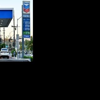 The sign of a Chevron gas station displays current prices as drivers pump gas in Rosemead, near Los Angeles, California in March 2026