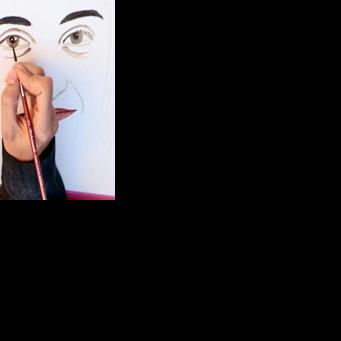 A protester draws a portrait of Mahdieh Esfandiari, an Iranian woman who was handed one year in prison for justifying terrorism in France