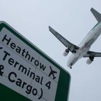 A plane flies in to land at Heathrow airport