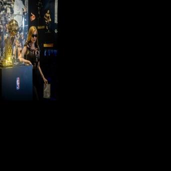 A tourist poses next to the NBA Championship trophy at the Venetian's NBA House in Macau