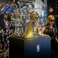 A tourist poses next to the NBA Championship trophy at the Venetian's NBA House in Macau