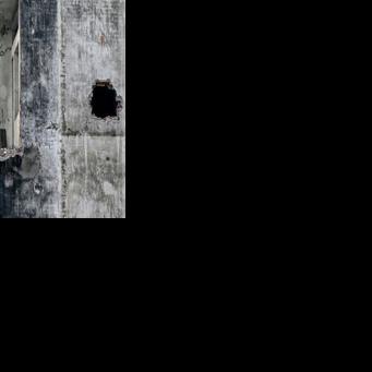 Workers dismantle part of a building at a demolition site in Hanoi on December 10, 2025.