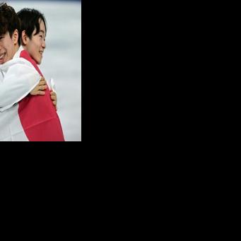 Japan's Yuma Kagiyama and Shun Sato hug each other after taking silver and bronze respectively in the Olympic men's singles free skating event in Milan