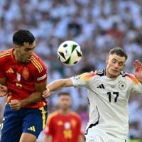 Spain's midfielder Mikel Merino fights for the ball with Germany's midfielder Florian Wirtz at Euro 2024