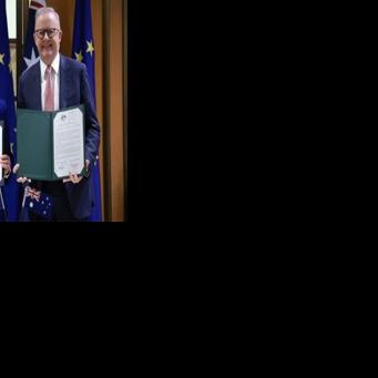 European Commission President Ursula von der Leyen (L) and Australian Prime Minister Anthony Albanese pose with signed copies of the agreements during a ceremony at Parliament House in Canberra on March 24, 2026.