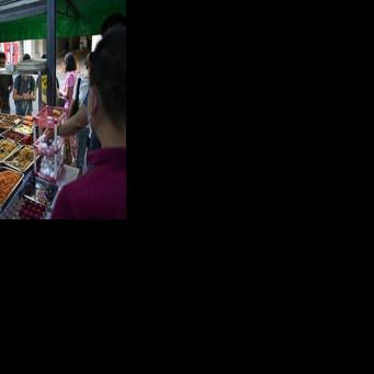 People buying food at a curbside canteen in Manila on April 7, 2026