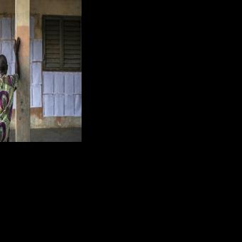A voter looks for his name on the electoral roll at a primary school serving as a polling station in Cotonou, Benin