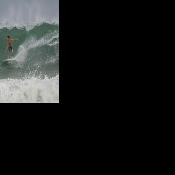 A surfer rides a wave at La Pared beach as Hurricane Erin approaches in Luquillo, Puerto Rico