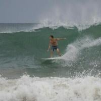 A surfer rides a wave at La Pared beach as Hurricane Erin approaches in Luquillo, Puerto Rico