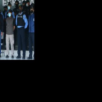 Former Honduras president Juan Orlando Hernandez (middle) was paraded in chains by police following his arrest on February 15, 2022 on suspicion of drug-trafficking