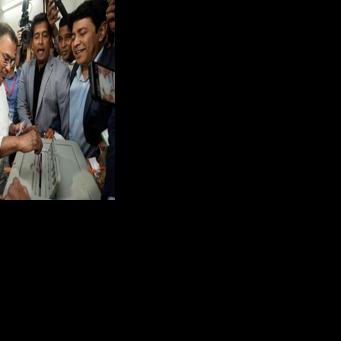 Bangladesh Nationalist Party (BNP) chairman and election candidate Tarique Rahman (C) casts his ballot on Thursday