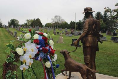 A statue of the late Leo Meyer and his British-trained Labrador retriever Bruce now stands watch over the cemetery in Johnsburg.