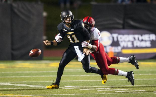 Appalachian State quarterback Taylor Lamb (left) fumbles after getting hit by Arkansas State linebacker Xavier Woodson. (Andrew Dye / Winston-Salem Journal)