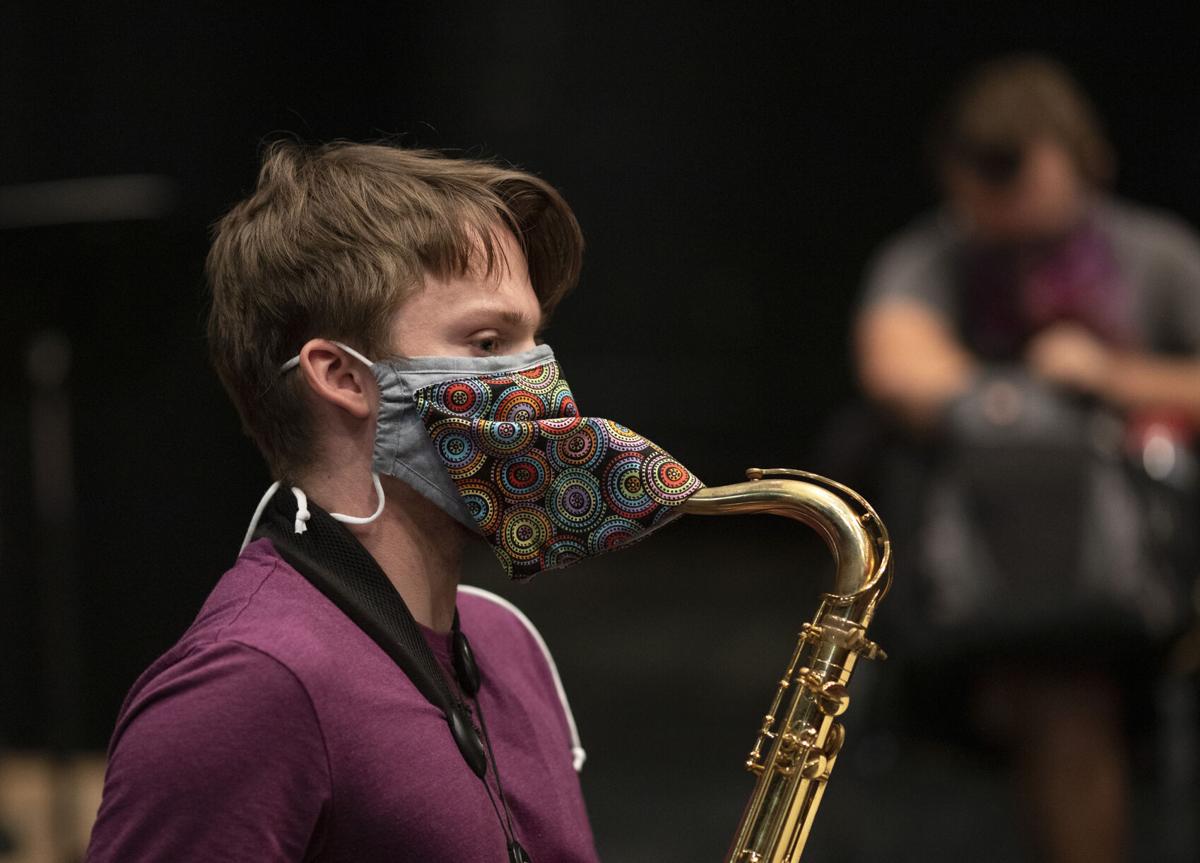 Musicians improvise masks for wind instruments to keep the band