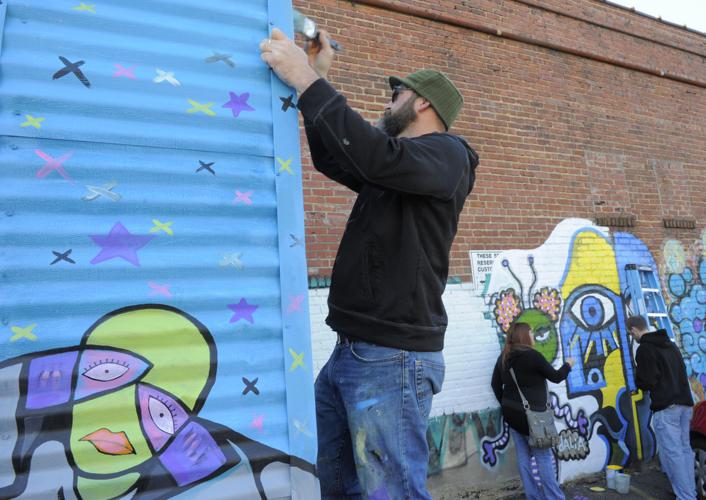 Artists work to convert graffiti to mural on Trade Street in WinstonSalem